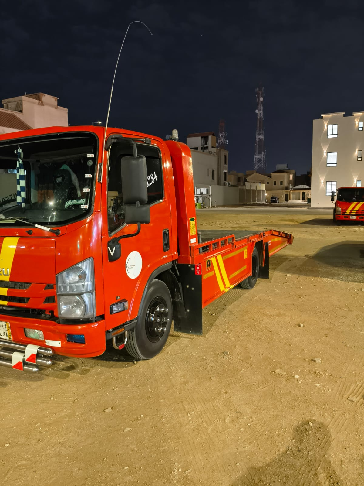 سطحة سيارات حمراء أثناء العمل ليلًا في الخرج